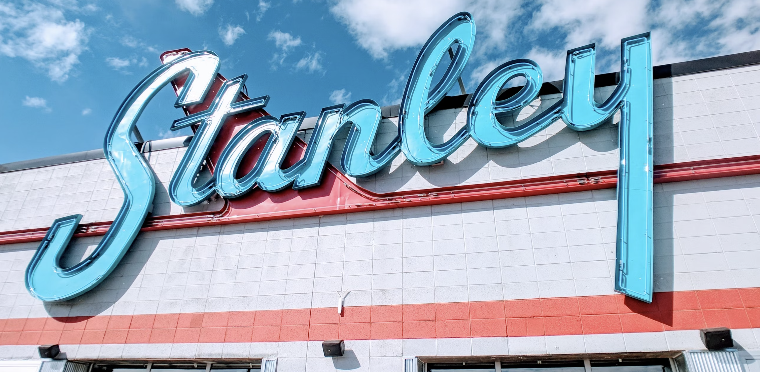 a custom storefront neon sign reading "Stanley" on a building.